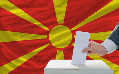 Image showing man voting on elections in macedonia in front of flag