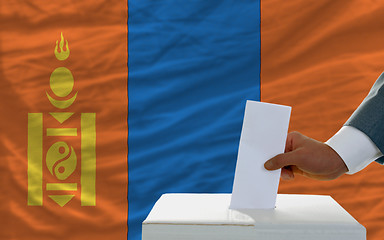 Image showing man voting on elections in mongolia in front of flag