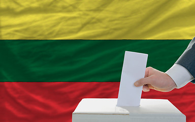 Image showing man voting on elections in lithuania in front of flag