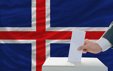 Image showing man voting on elections in iceland in front of flag