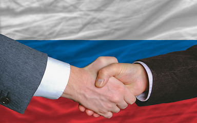 Image showing businessmen handshake after good deal in front of russia flag