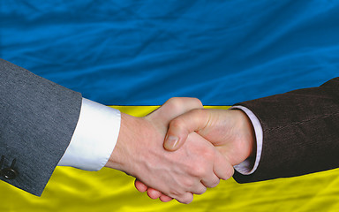 Image showing businessmen handshake after good deal in front of ukraine flag