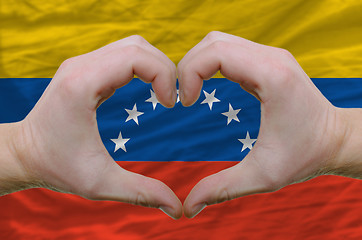 Image showing Heart and love gesture showed by hands over flag of venezuela ba