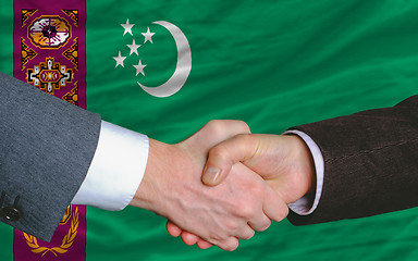 Image showing businessmen handshake after good deal in front of turkmenistan f