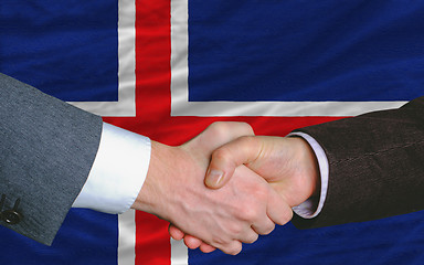 Image showing businessmen handshake after good deal in front of iceland flag