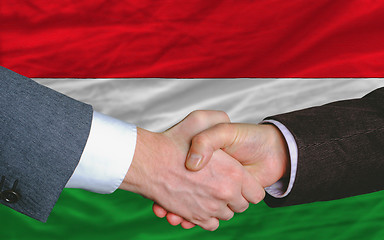 Image showing businessmen handshake after good deal in front of hungary flag
