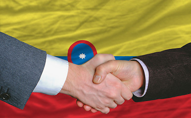 Image showing businessmen handshakeafter good deal in front of columbia flag