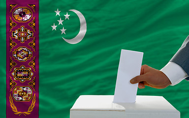 Image showing man voting on elections in turkmenistan in front of flag