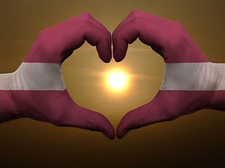 Image showing Heart and love gesture by hands colored in latvia flag during be