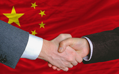 Image showing businessmen handshakeafter good deal in front of china flag