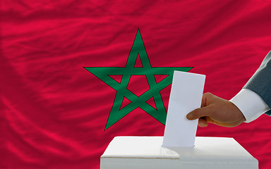 Image showing man voting on elections in morocco in front of flag