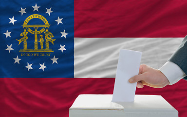 Image showing man voting on elections in georgia in front of flag