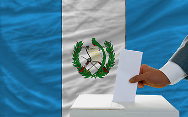 Image showing man voting on elections in guatemala in front of flag