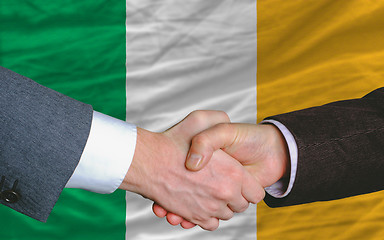 Image showing businessmen handshake after good deal in front of ireland flag