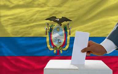 Image showing man voting on elections in ecuador in front of flag