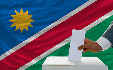 Image showing man voting on elections in namibia in front of flag