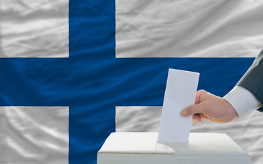 Image showing man voting on elections in finland in front of flag