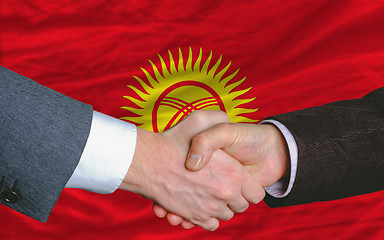 Image showing businessmen handshake after good deal in front of kyrghyzstan fl