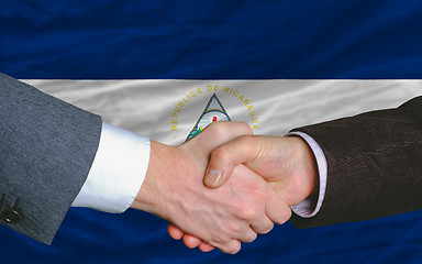 Image showing businessmen handshake after good deal in front of nicaragua flag