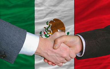 Image showing businessmen handshake after good deal in front of mexico flag