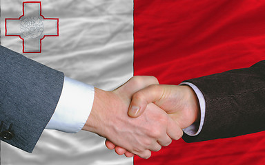 Image showing businessmen handshake after good deal in front of malta flag