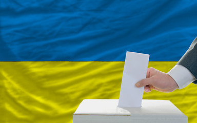 Image showing man voting on elections in ukraine in front of flag