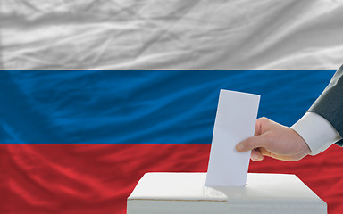 Image showing man voting on elections in russia in front of flag