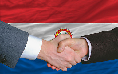 Image showing businessmen handshake after good deal in front of paraguay flag