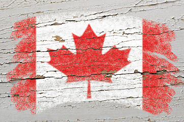 Image showing flag of Canada on grunge wooden texture painted with chalk  