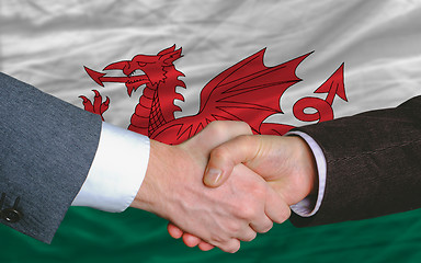 Image showing businessmen handshake after good deal in front of wales flag