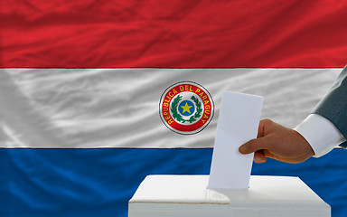 Image showing man voting on elections in paraguay in front of flag