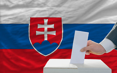 Image showing man voting on elections in slovakia in front of flag