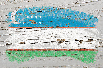 Image showing flag of uzbekistan on grunge wooden texture painted with chalk  