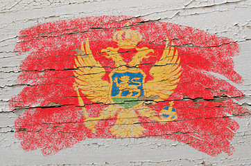 Image showing flag of montenegro on grunge wooden texture painted with chalk  