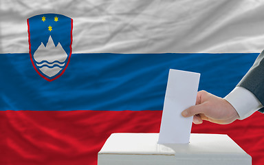 Image showing man voting on elections in slovenia in front of flag