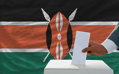 Image showing man voting on elections in kenya in front of flag