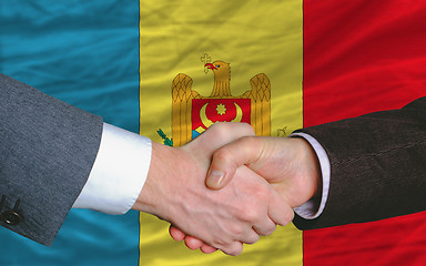 Image showing businessmen handshake after good deal in front of moldova flag