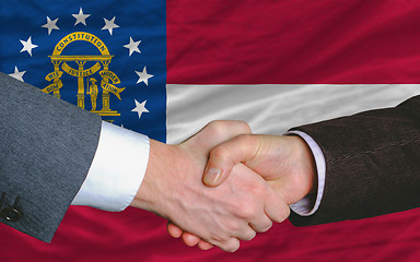 Image showing businessmen handshake after good deal in front of georgia flag