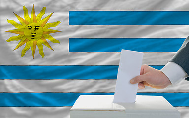 Image showing man voting on elections in uruguay in front of flag
