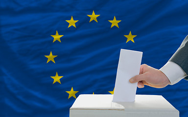 Image showing man voting on elections in europe in front of flag