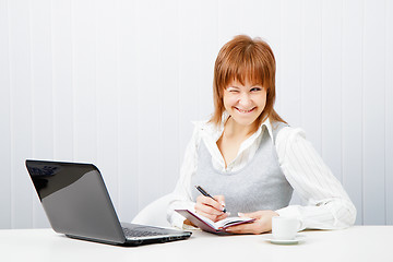 Image showing smiling attractive girl with a notebook. Office worker