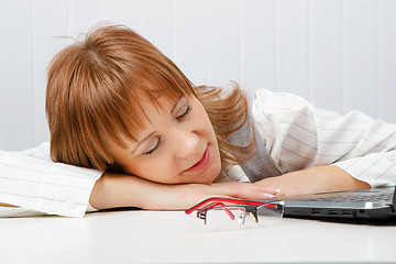 Image showing Tired girl lies on a table