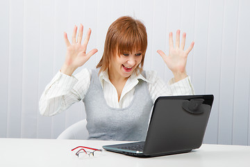 Image showing Delighted girl looks at a monitor