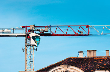 Image showing Big industrial crane against blue sky building a house