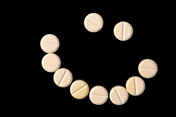 Image showing Smiling face made out of pills on black background