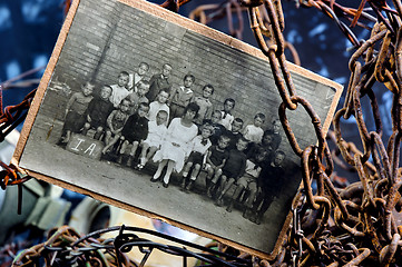 Image showing Photo of sad children in a group between rusty chains