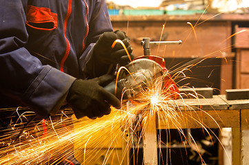 Image showing Circular saw and a worker in a hard job