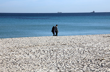 Image showing Couple walking on the beach enjoying the vacation
