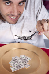 Image showing Man eating little dollar banknote