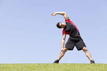 Image showing Athlete warming and stretching